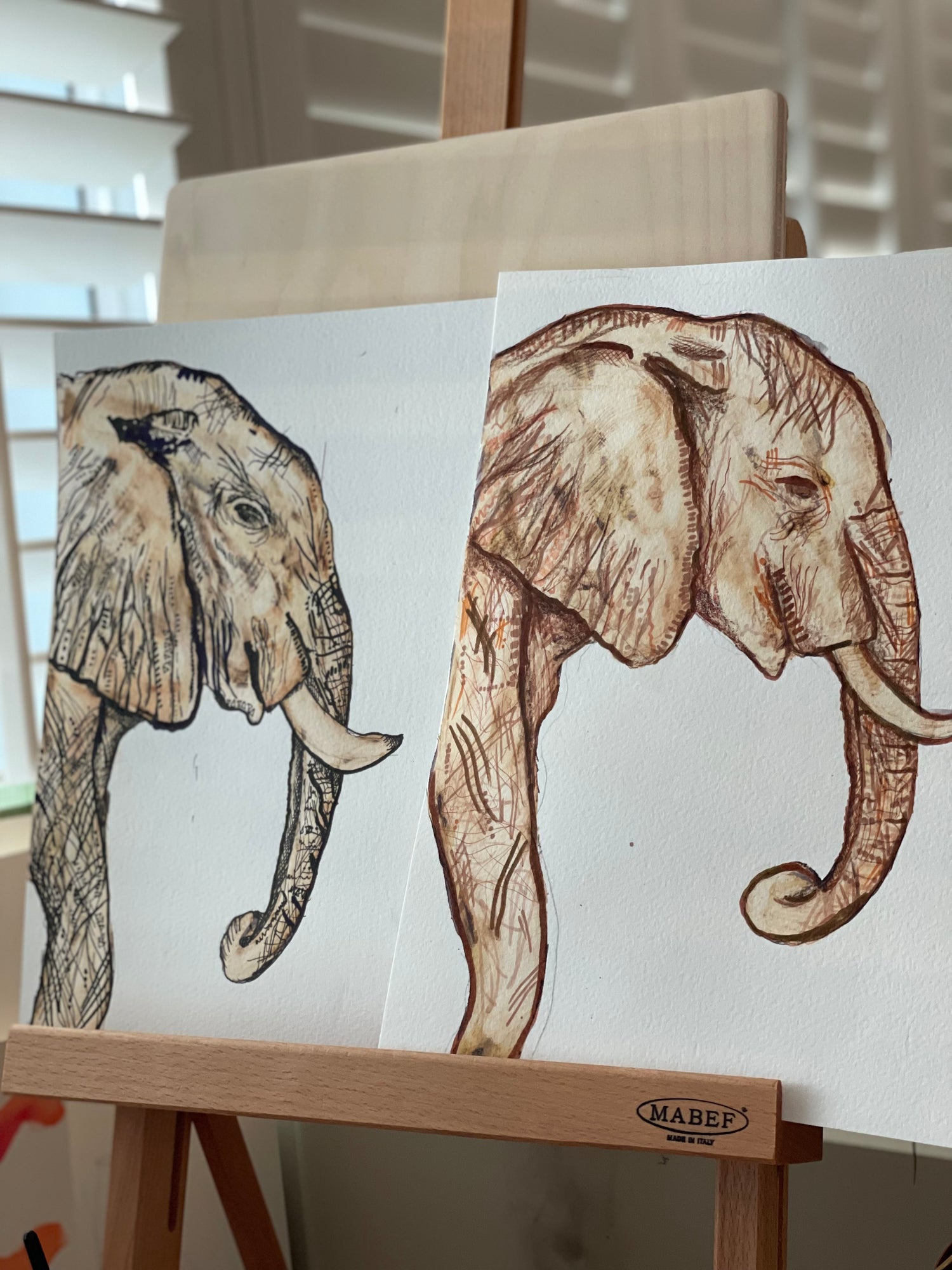 Two ink and bleach elephants on art stand
