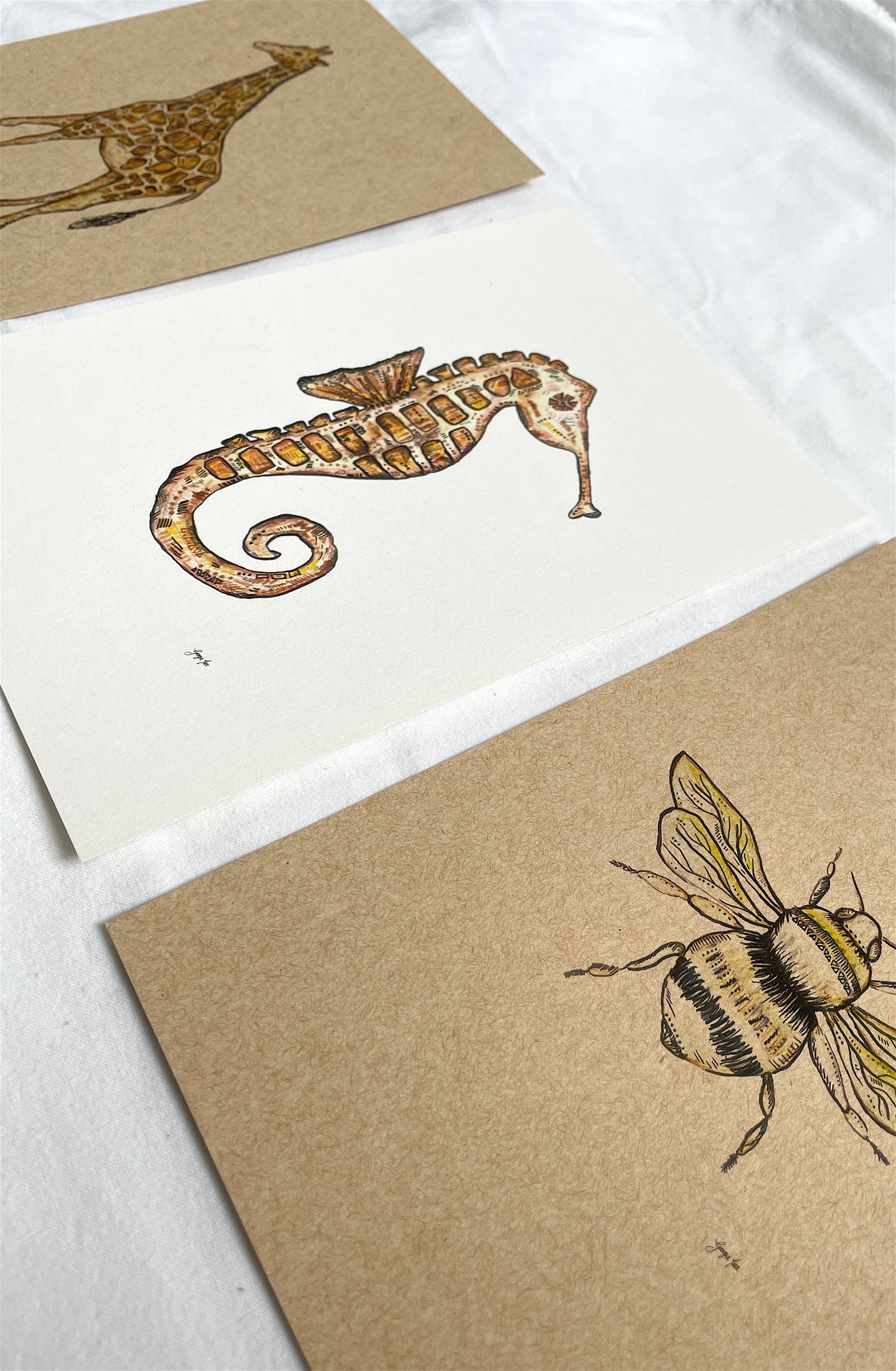 A set of three prints including a Giraffe, Bee & Seahorse