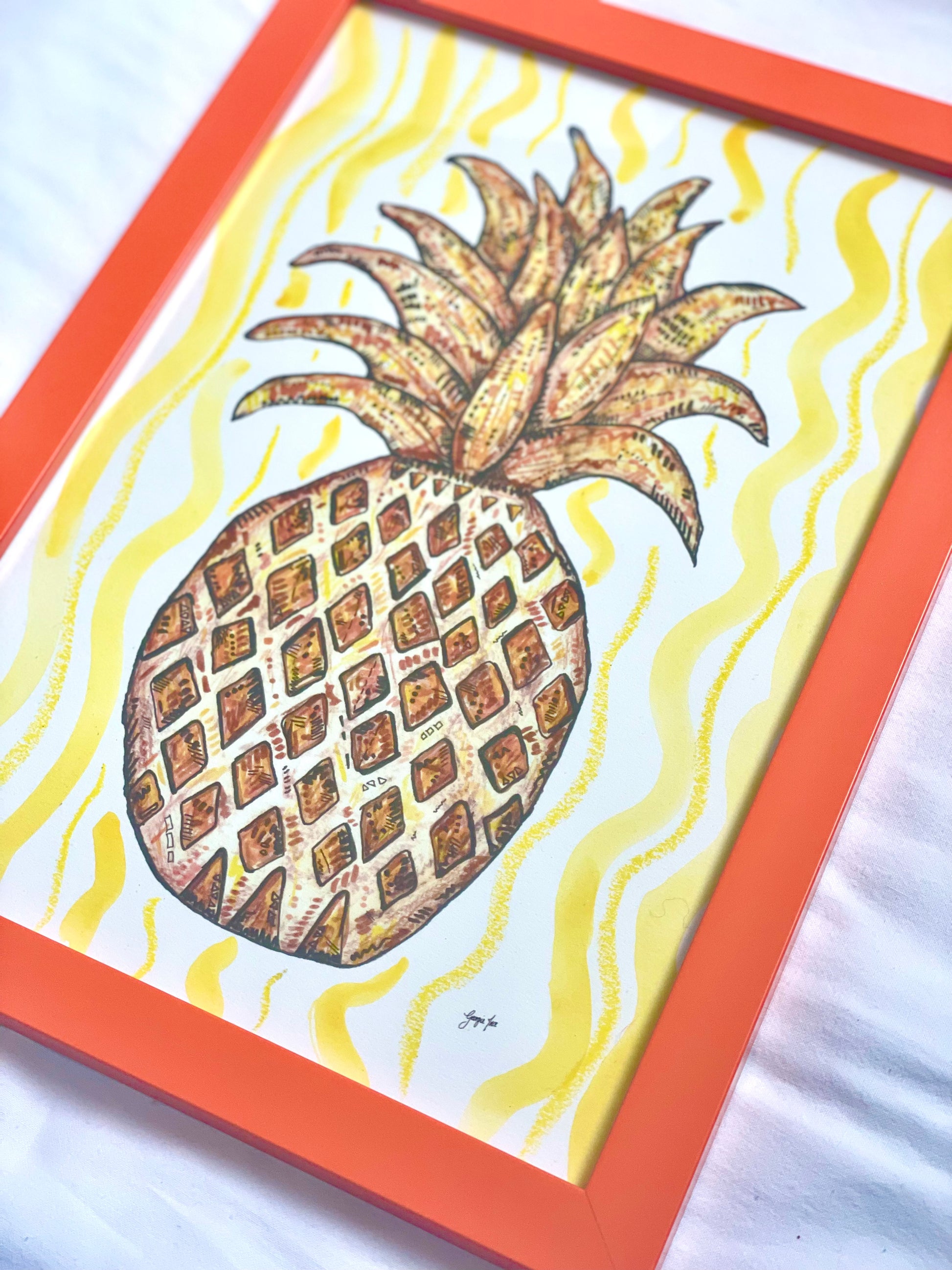 A framed pineapple print (A4) with yellow hand painted watercolour and oil pastel background. 